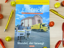 Die neue Ausgabe Unternehmenszeitschrift „Ein.Blick“ (2025/02) liegt auf dem Tisch umgeben von gelben und orangenen Kugelschreibern