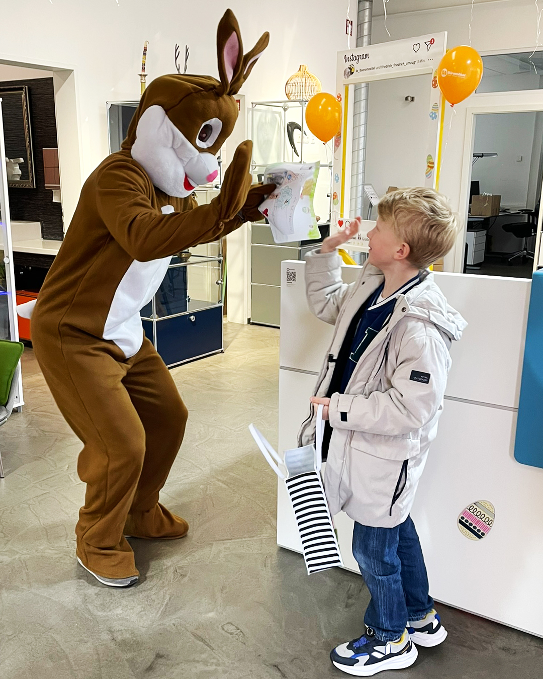 Osterhase gibt einem Jungen ein High-Five für das geschenkte Bild