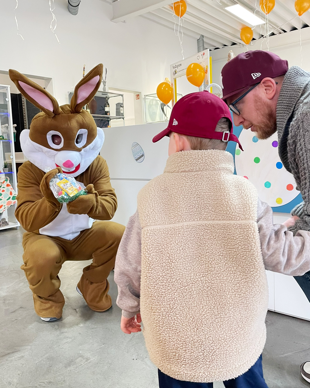 Osterhase überreicht einem kleinem Besucher sein Ostergeschenk